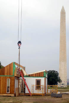 Photo of a solar home with a cable attached to the roof; the Washington Monument is in the background.