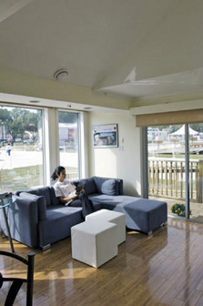 Photo of a student team member sitting on a sofa inside their Solar Decathlon house.