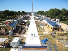 Aerial photo of two rows of houses along a walkway, with the National Monument in the background.