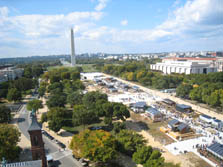 Photo of small houses on either side of a wide path. The Washington Monument is shown in the distance.