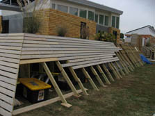 Photo of a house with angled decking that is partially dismantled.