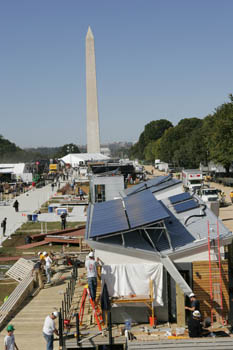 Photo of a row of houses under construction. The Washington Monument is in the background.