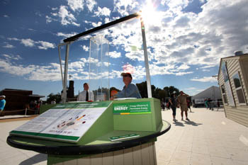 Photo of a man standing behind an Department of Energy Office of Energy Efficiency and Renewable Energy exhibit in the middle of the National Mall.