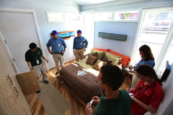 Photo of four Solar Decathlon officials and two students in a tour of the bedroom of the Team Missouri home.
