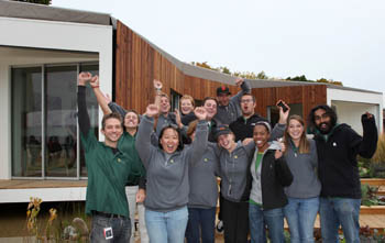 Photo of a group of students cheering in front of the Team California house.