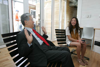 Photo of Daniel Akaka and Mariko Fujo-White sitting in chairs and talking in a light-filled room.