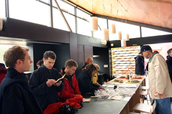 Photo of numerous people inspecting items on the University of Arizona countertop and writing notes in small notebooks.