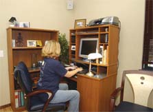 Photo of a student working at a computer in a home office.
