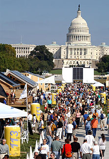 Photo of the Solar Decathlon Solar Village on the National Mall, with the crowds of people and the U.S. Capitol Building in the background.