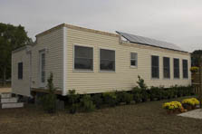 Photo of a square house with PV panels angled off the roof.