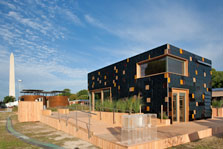 Photo of surPLUShome at the U.S. Department of Energy Solar Decathlon 2009 with Silo House and the Washington Monument in the background.