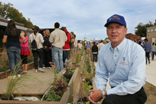 Photo of Richard King next to a deck and planter boxes. Decathlete Way and the U.S. Capitol are in the background.